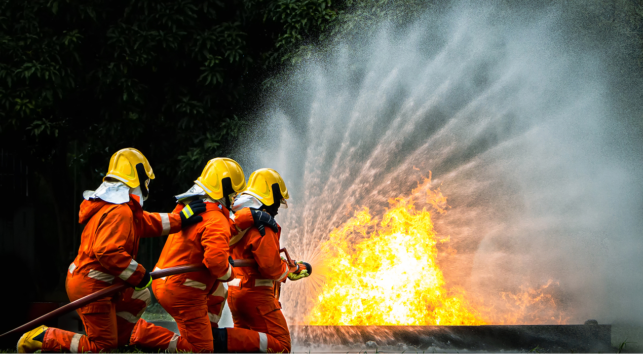 Yangın sigortasının önemini anlatan, alevlere müdahale eden itfaiyeciler görseli.