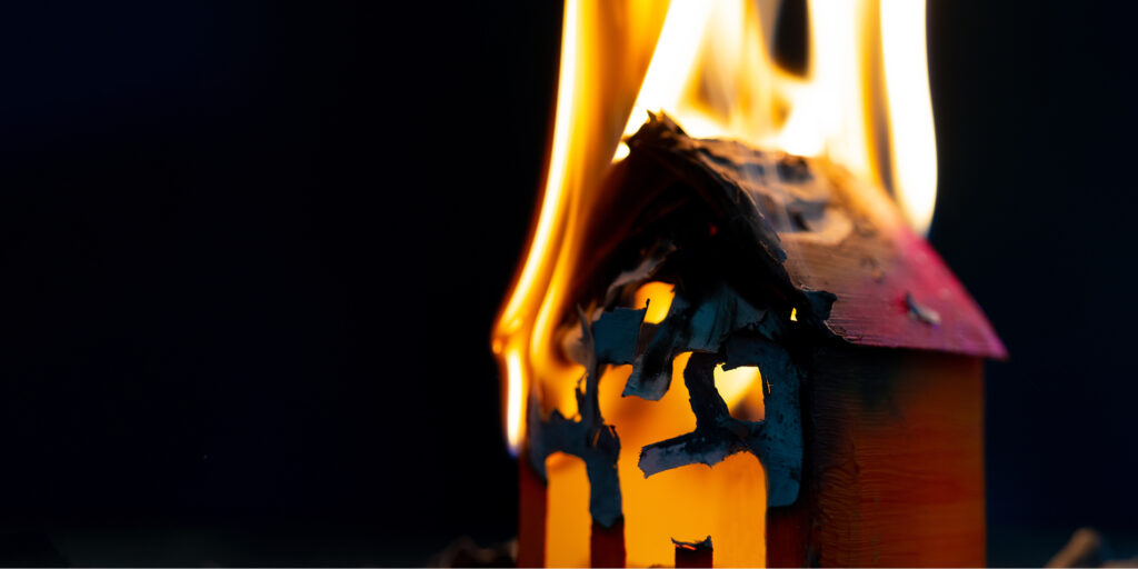 Yangın sigortasının önemini anlatan, alevler içinde yanan ev maketi görseli.